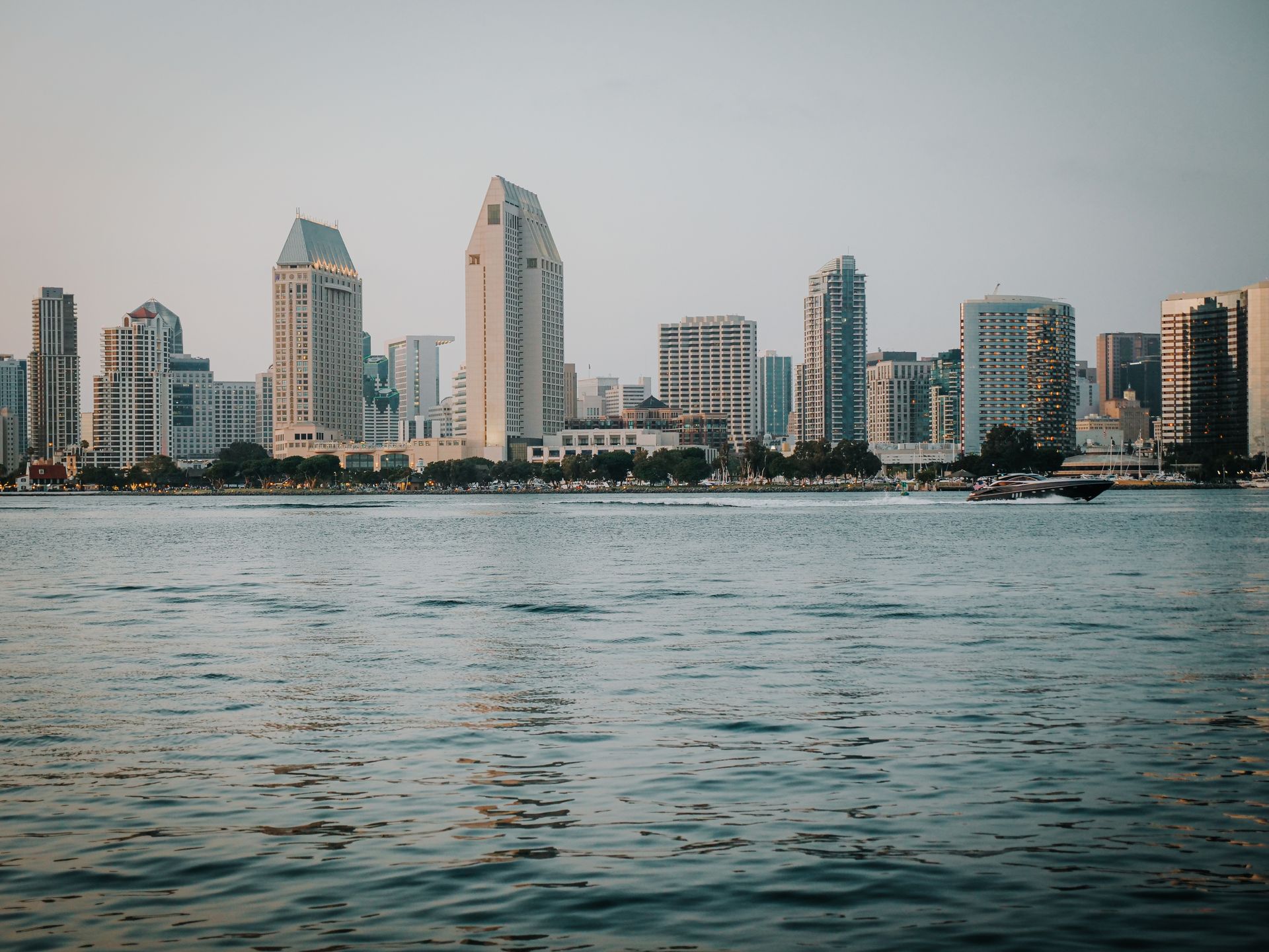 Downtown San Diego skyline across San Diego Bay, with a boat on the water.